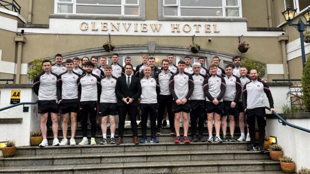 Guests stand on grand stone steps outside Glenview Hotel, a charming retreat with classic architecture and beautiful gardens.
