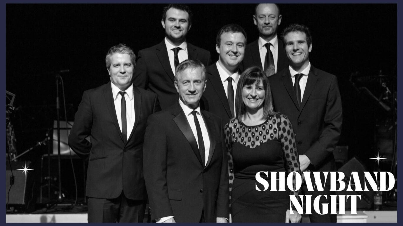 A group of six men and one woman in formal attire stand together on stage with the text