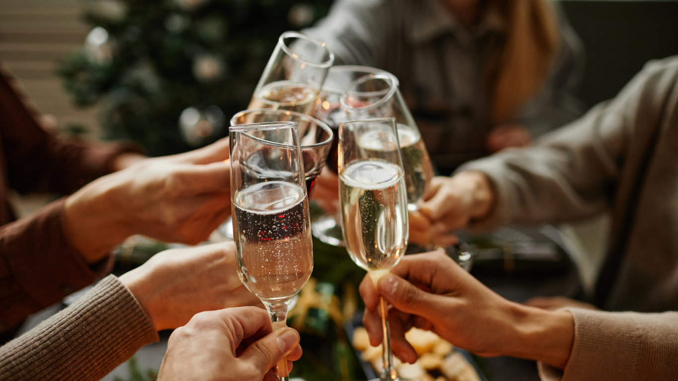 Guests celebrating with champagne in elegant hotel setting, surrounded by festive decor for a joyous and relaxing stay.